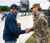 An active duty soldier shakes the hand of a Vietnam veteran at the West Potomac Park outdoor stage